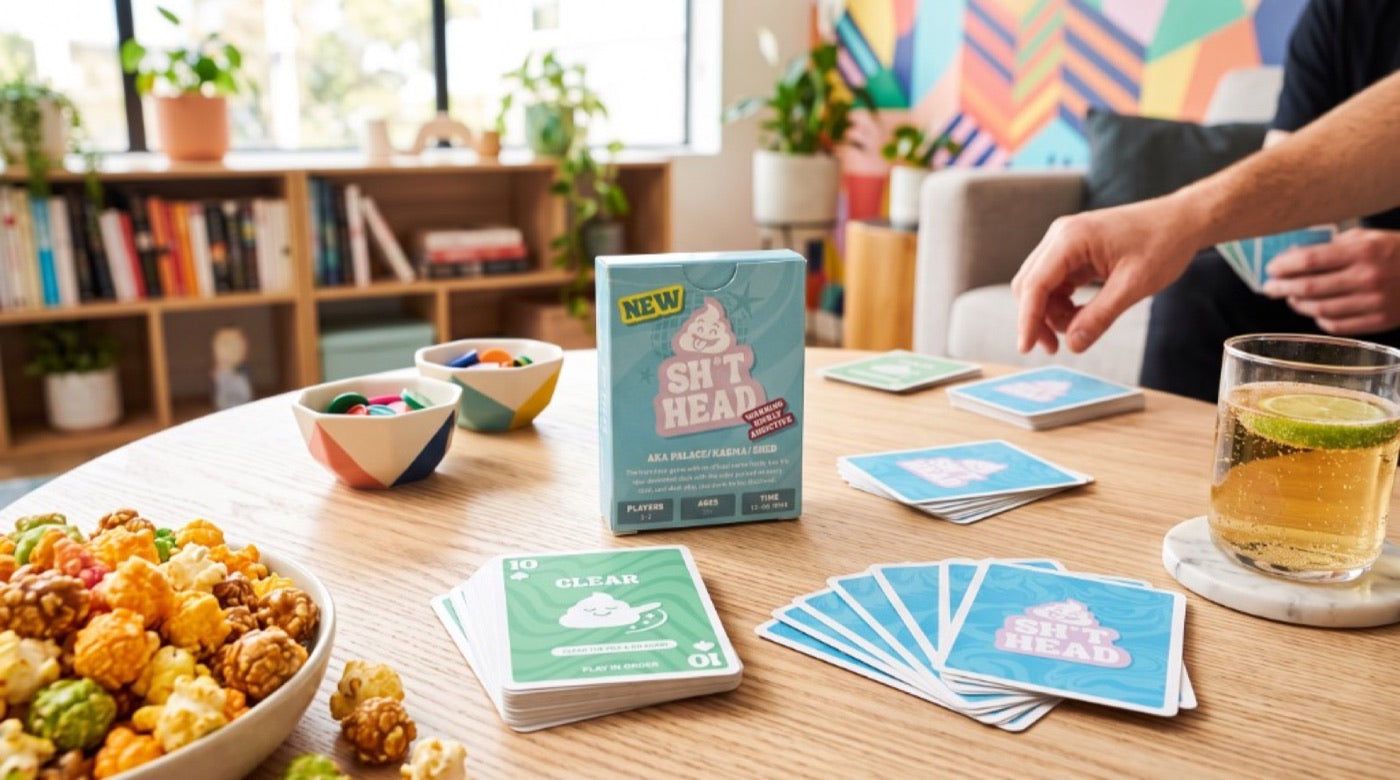 Friends playing Sh*thead Card Game on a coffee table with snacks and drinks